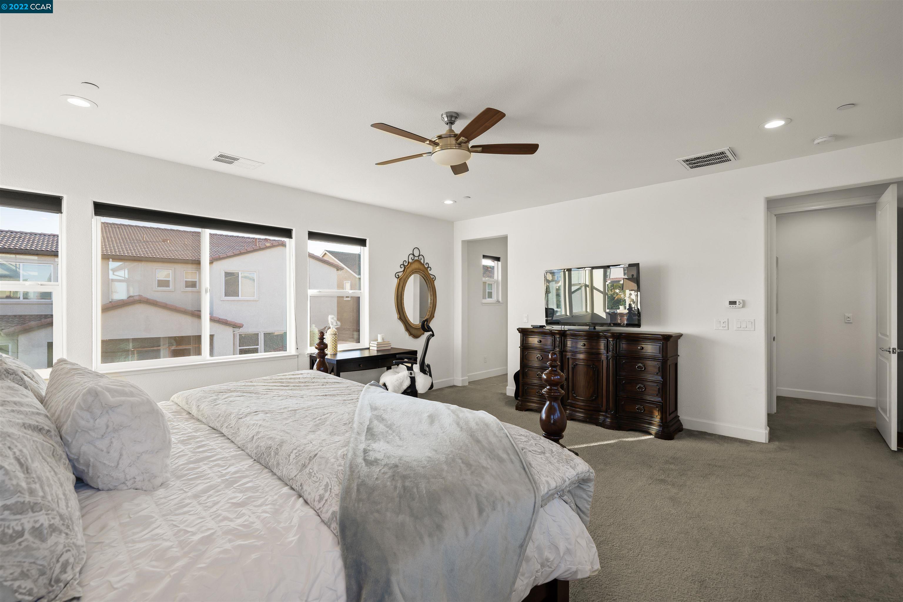 2468 Flag Stop Way Tracy, CA 95377 - Photo 14 of 36 a spacious bedroom with a bed and a large window