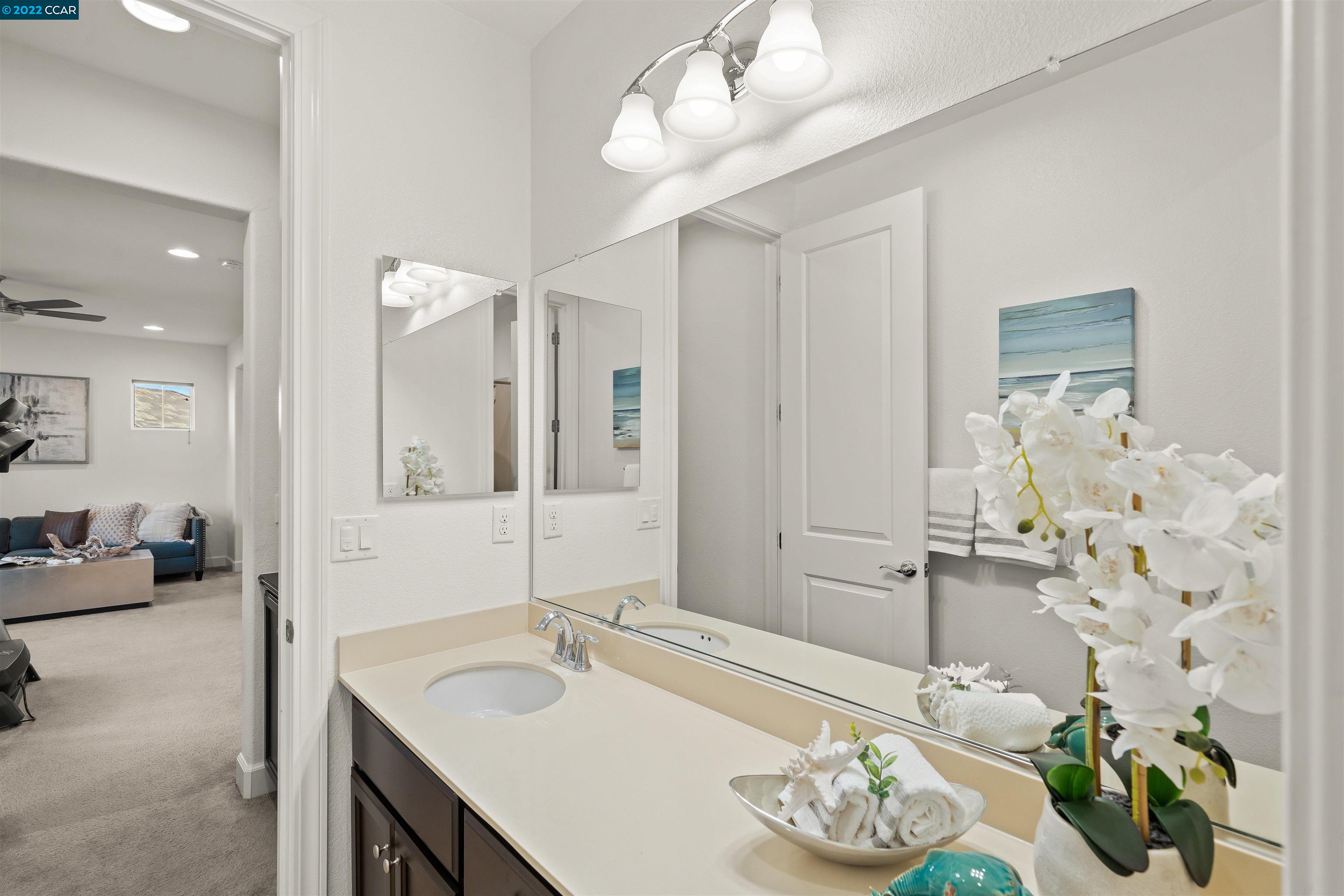 2468 Flag Stop Way Tracy, CA 95377 - Photo 18 of 36 a bathroom with a granite countertop sink and a mirror