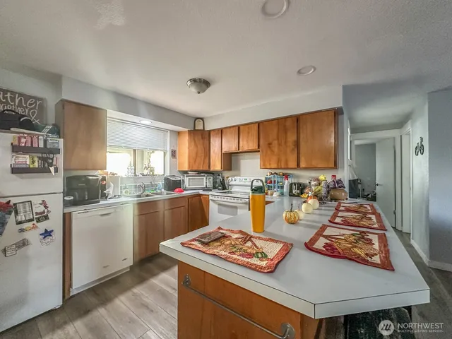 a living room with furniture and a open kitchen view