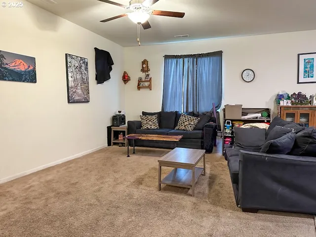a living room with furniture and a air conditioner vent