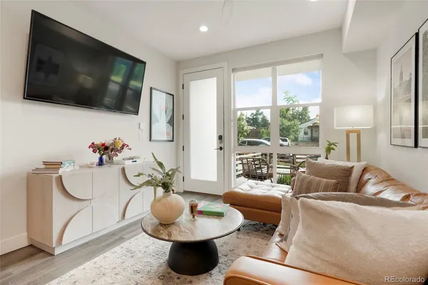a living room with furniture a flat screen tv and a floor to ceiling window
