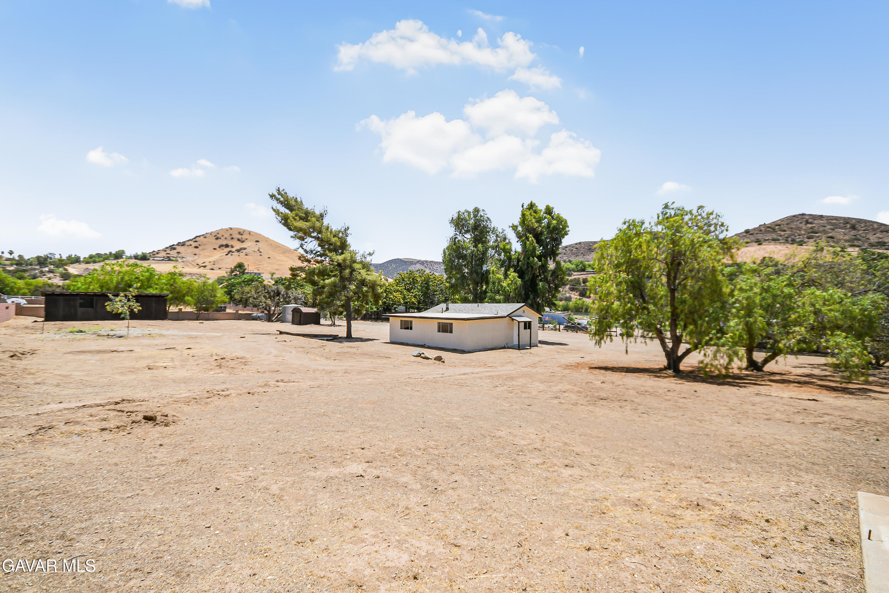 a backyard of a house with large trees and outdoor space