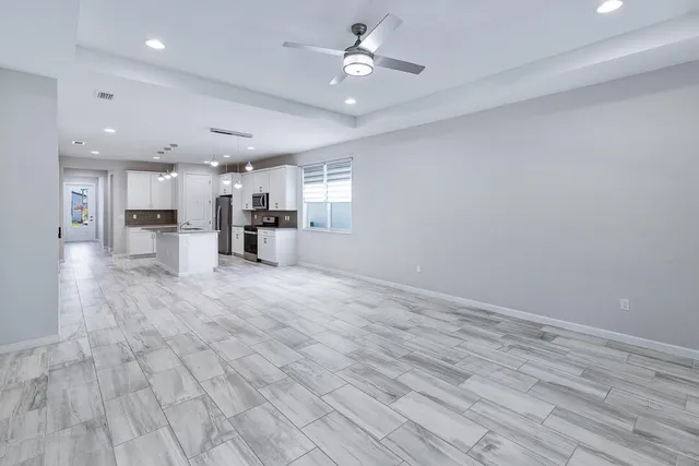 a kitchen with kitchen island granite countertop a stove a sink a refrigerator a center island and cabinets