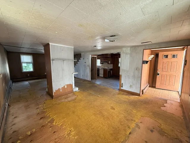 a view of an empty room with closet and a window