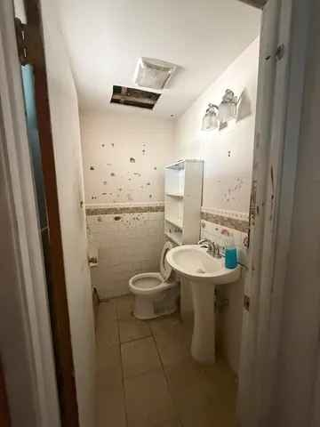 a bathroom with a sink a toilet and a mirror