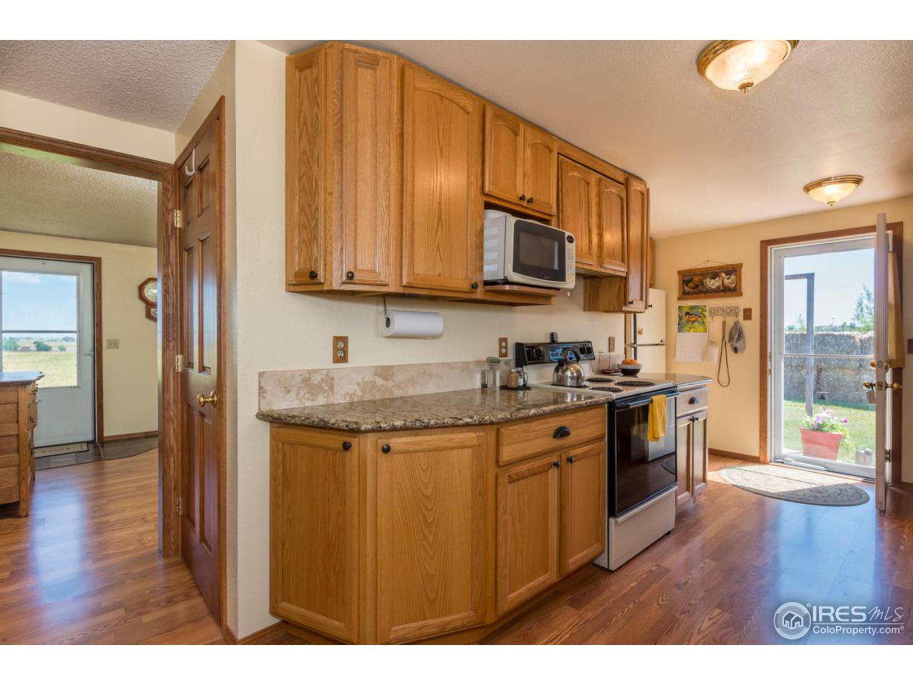 12000 Wasatch Road Longmont, CO 80504 - Photo 8 of 27 a kitchen with stainless steel appliances granite countertop a stove a sink and a microwave