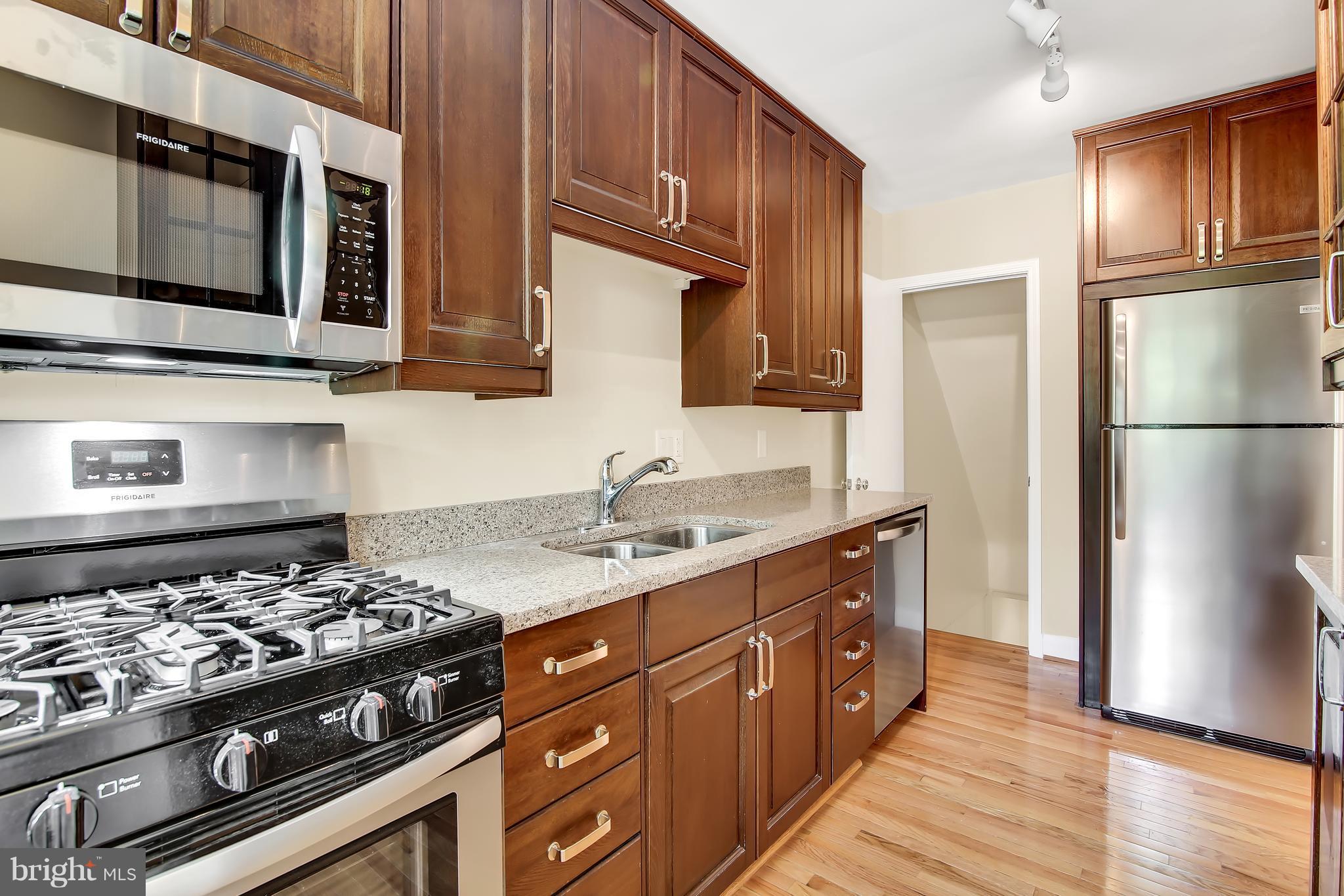 7134 Heathfield Road Baltimore, MD 21212 - Photo 11 of 28 a kitchen with stainless steel appliances granite countertop a stove a refrigerator and a microwave