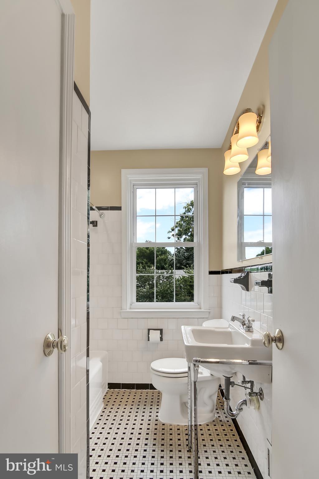 7134 Heathfield Road Baltimore, MD 21212 - Photo 16 of 28 a bathroom with a sink a toilet and a window