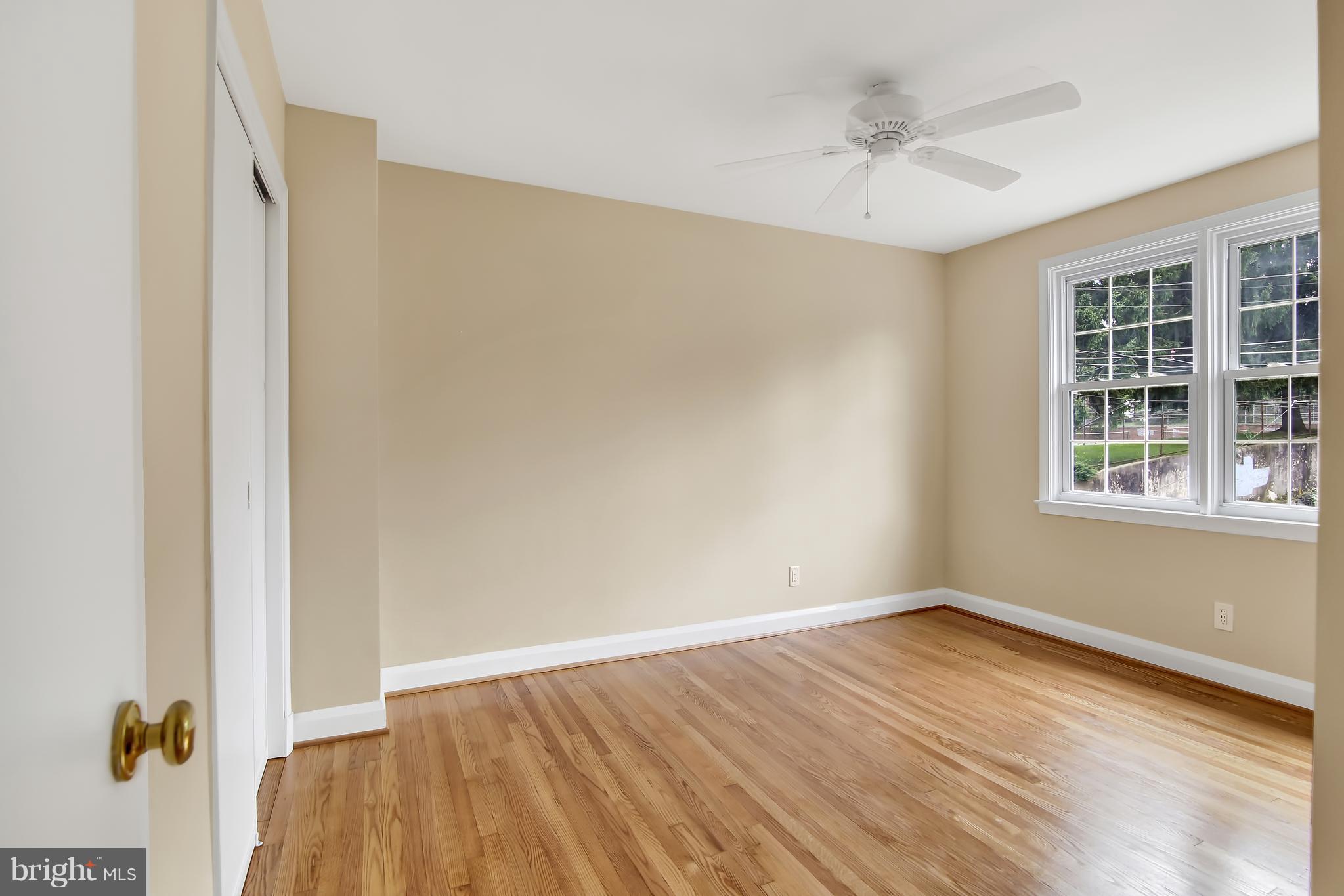 7134 Heathfield Road Baltimore, MD 21212 - Photo 17 of 28 a view of an empty room with a window and wooden floor