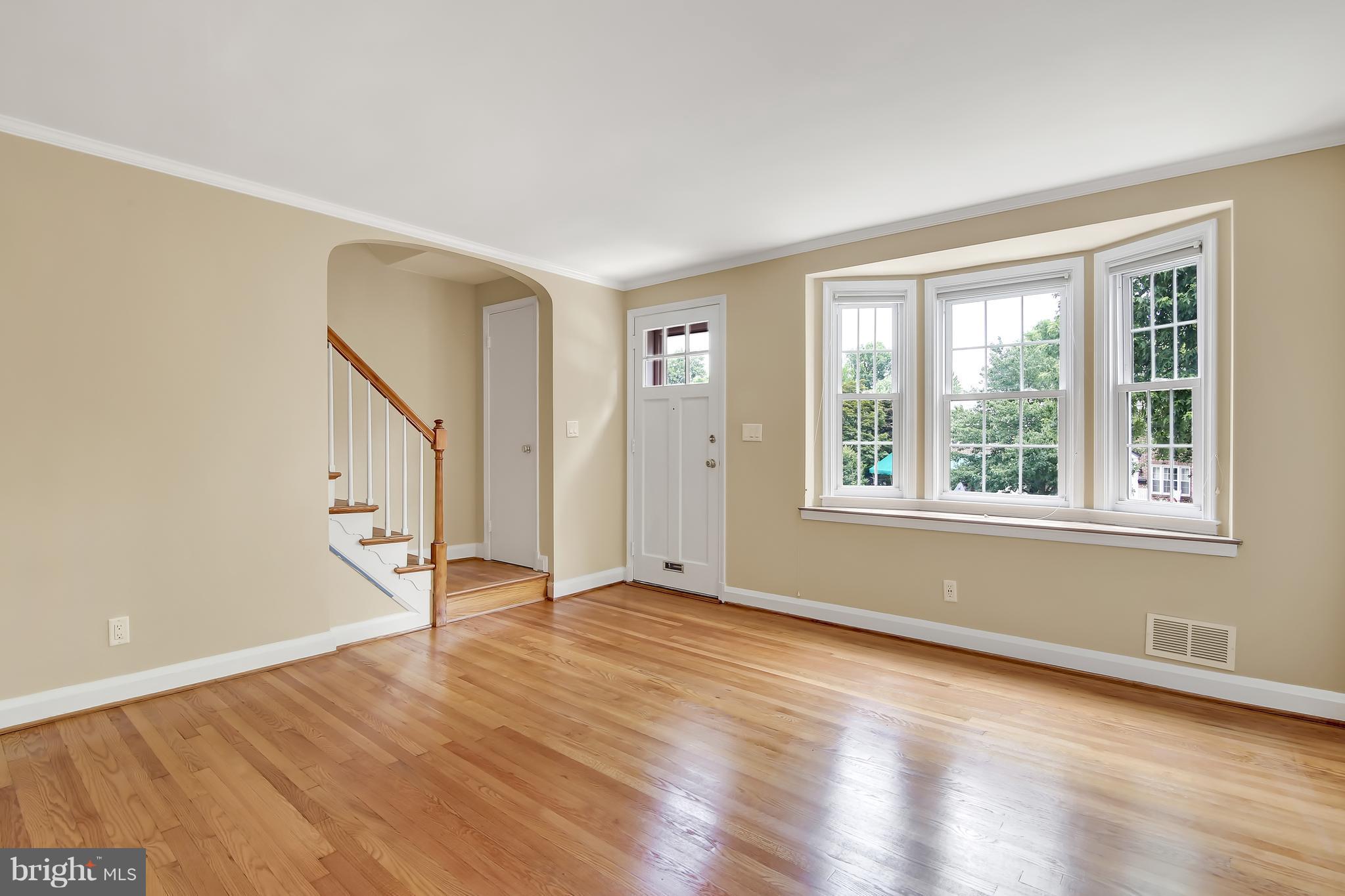 7134 Heathfield Road Baltimore, MD 21212 - Photo 5 of 28 a view of an empty room with wooden floor and a window