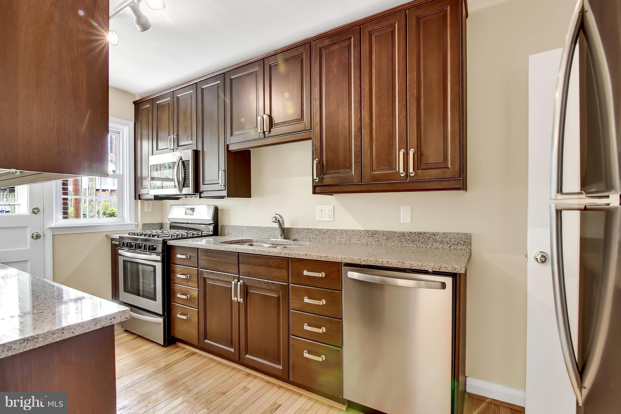 7134 Heathfield Road Baltimore, MD 21212 - Photo 9 of 28 a kitchen with stainless steel appliances granite countertop a refrigerator sink and cabinets