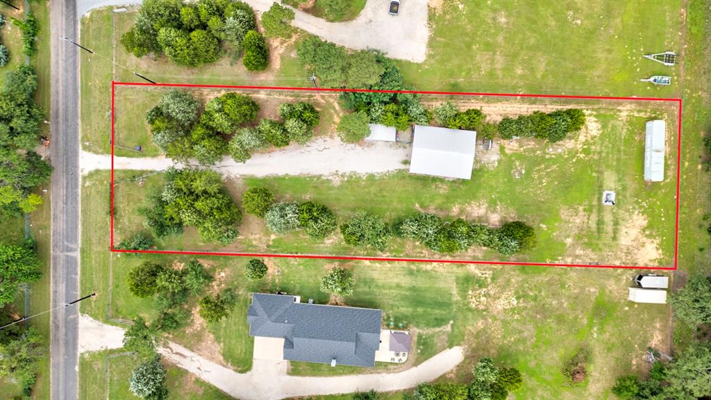 1469 Cedar Mills Road Gordonville, TX 76245 - Photo 11 of 12 Expansive rectangular parcel featuring a gravel driveway, mature trees, and a metal outbuilding