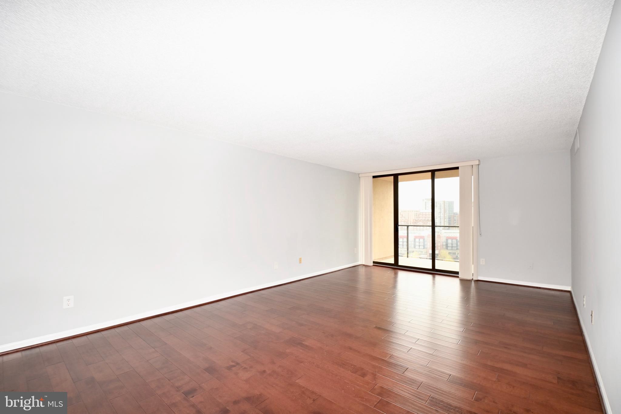 1101 South Arlington Ridge Road, Unit 509 Arlington, VA 22202 - Photo 13 of 62 an empty room with wooden floor and windows