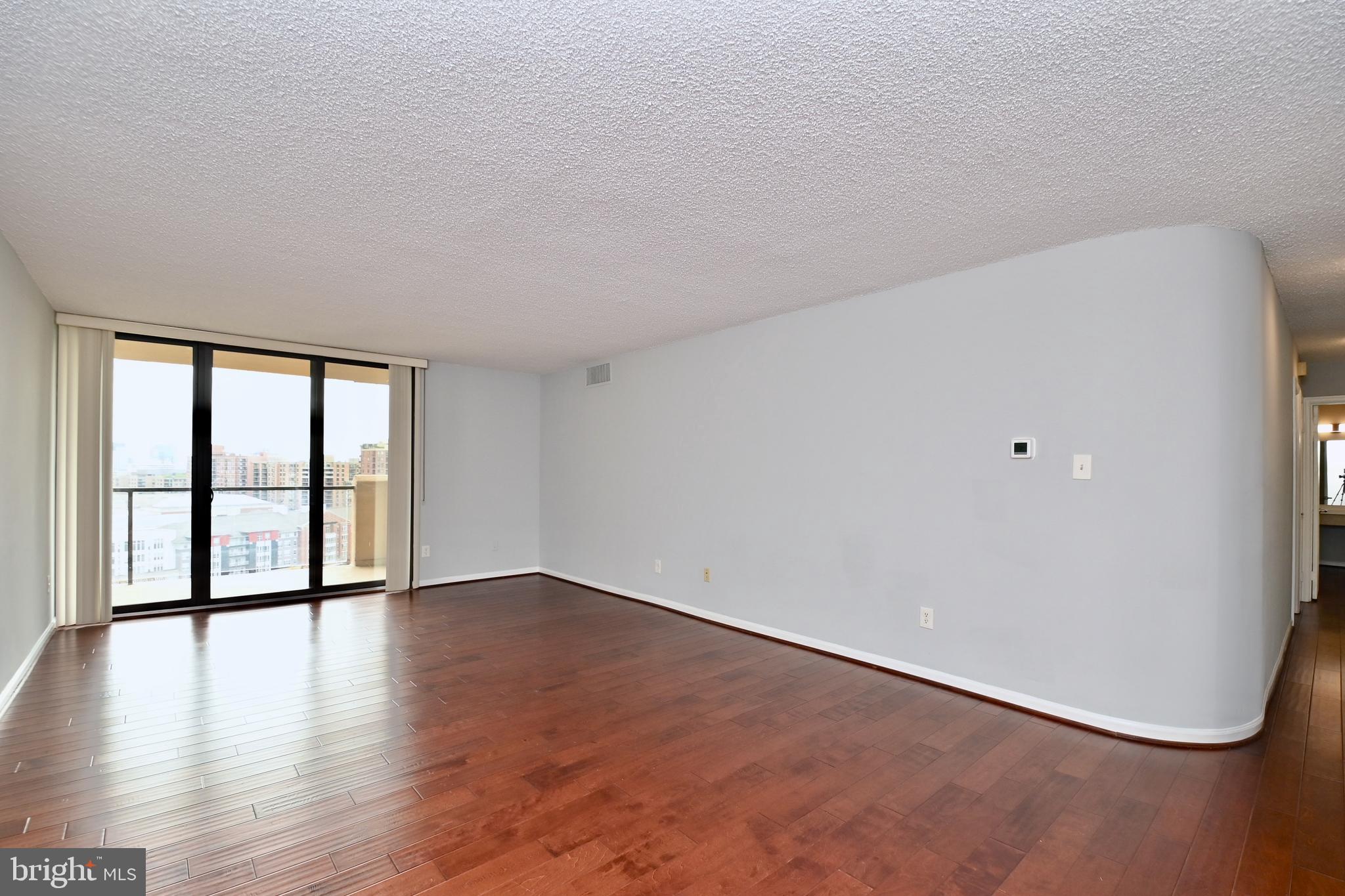 1101 South Arlington Ridge Road, Unit 509 Arlington, VA 22202 - Photo 14 of 62 a view of an empty room with wooden floor and a window