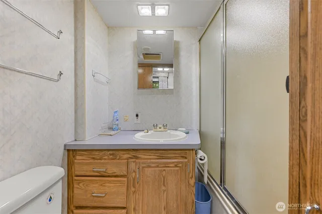a bathroom with a granite countertop sink a mirror and a toilet