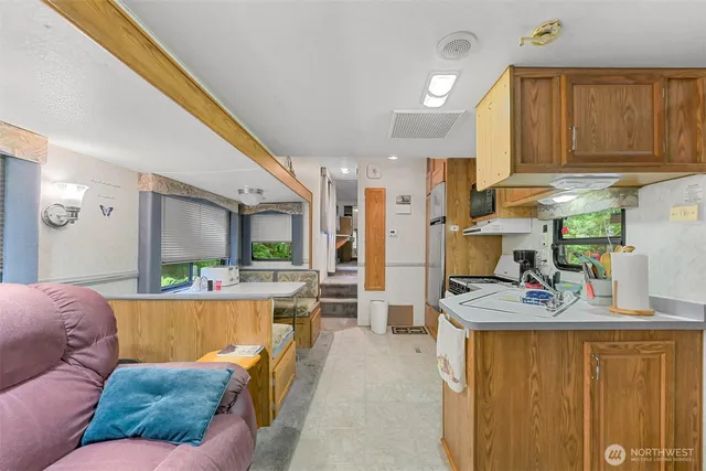 a view of kitchen with kitchen island stainless steel appliances refrigerator stove microwave and cabinets