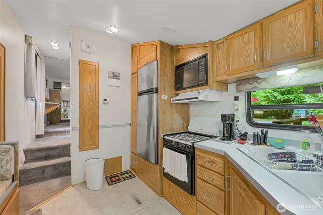 a kitchen with stainless steel appliances a stove a sink and a refrigerator