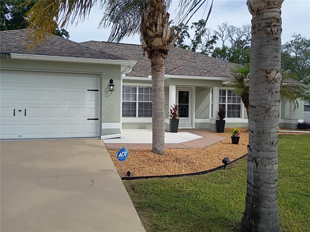3497 Chadwick Avenue Spring Hill, FL 34609 - Photo 1 of 47 a front view of a house with garden