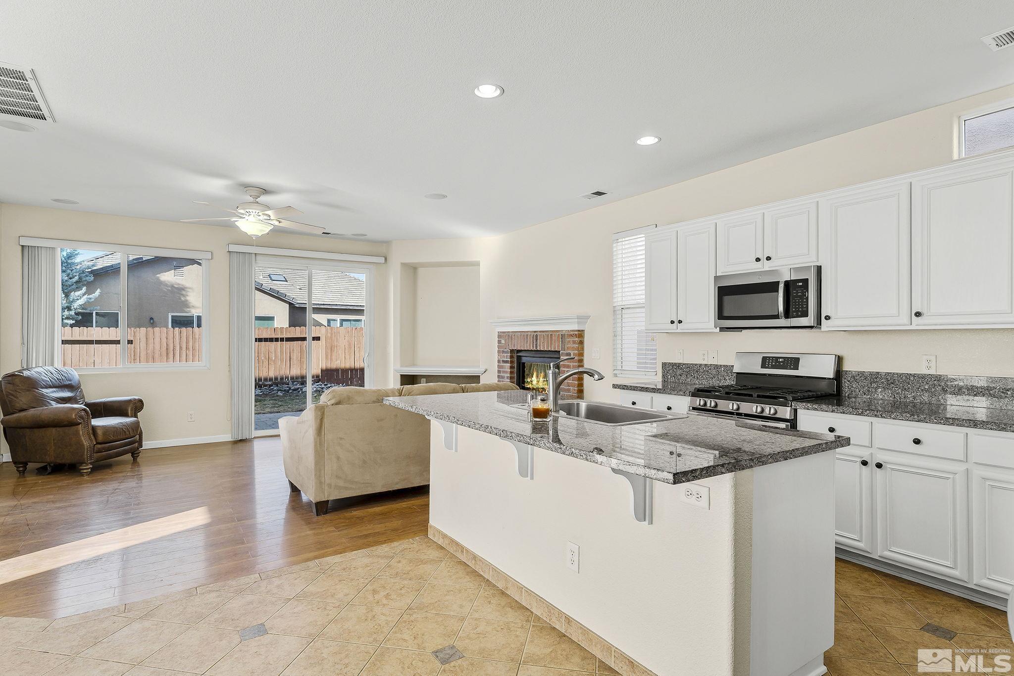 10525 Yuba Court Reno, NV 89521 - Photo 5 of 13 a kitchen with stainless steel appliances granite countertop a stove sink and cabinets
