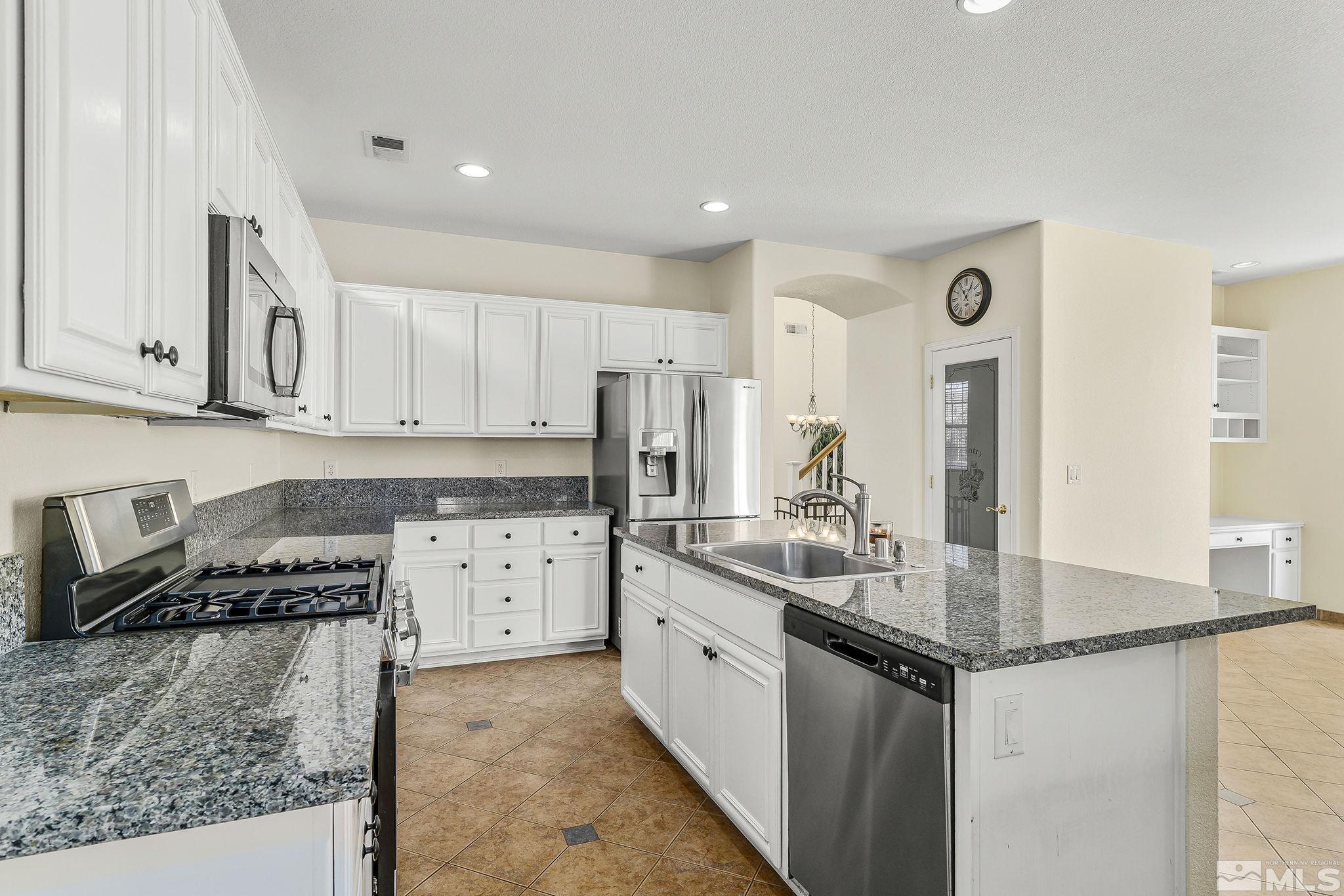 10525 Yuba Court Reno, NV 89521 - Photo 6 of 13 a kitchen with stainless steel appliances granite countertop a sink stove and refrigerator