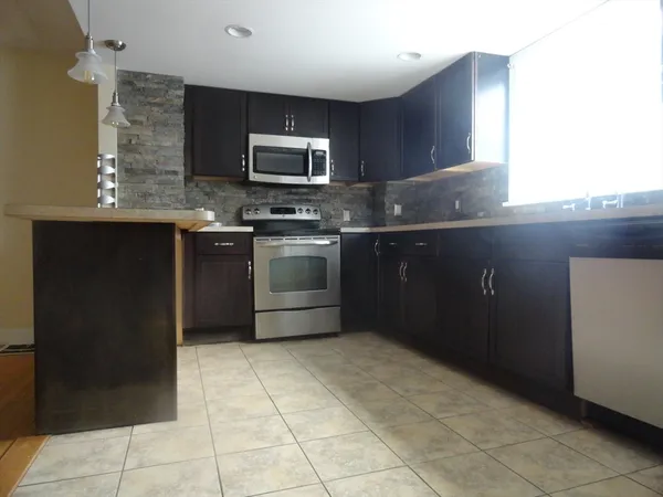 a kitchen with stainless steel appliances granite countertop a refrigerator and a stove