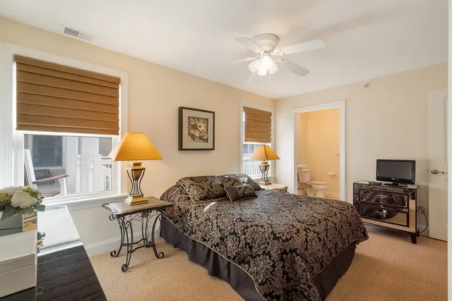 a bedroom with a bed a chandelier and a flat screen tv