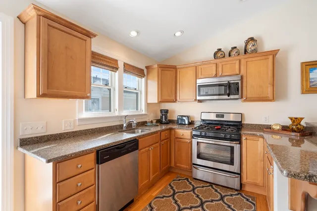 a kitchen with stainless steel appliances a stove sink microwave and cabinets