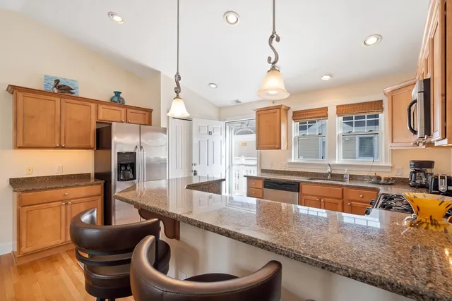 a kitchen with stainless steel appliances granite countertop a sink and a refrigerator