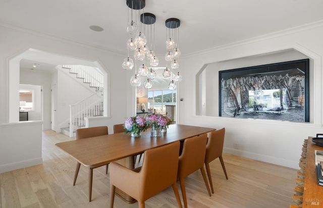 a dining room with furniture a chandelier and wooden floor