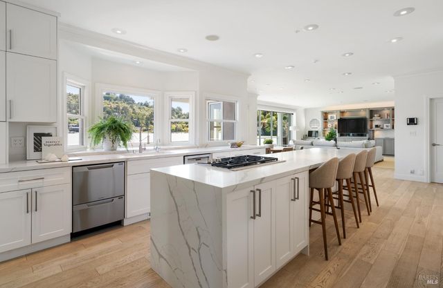 a kitchen with white cabinets and sink