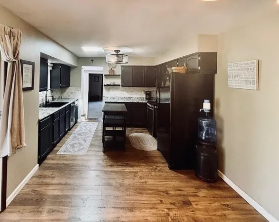 a kitchen with stainless steel appliances kitchen island granite countertop a refrigerator and a stove top oven