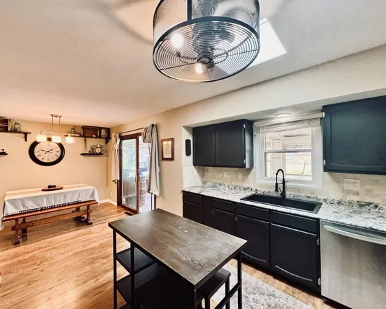 a kitchen with granite countertop a stove a sink and a microwave