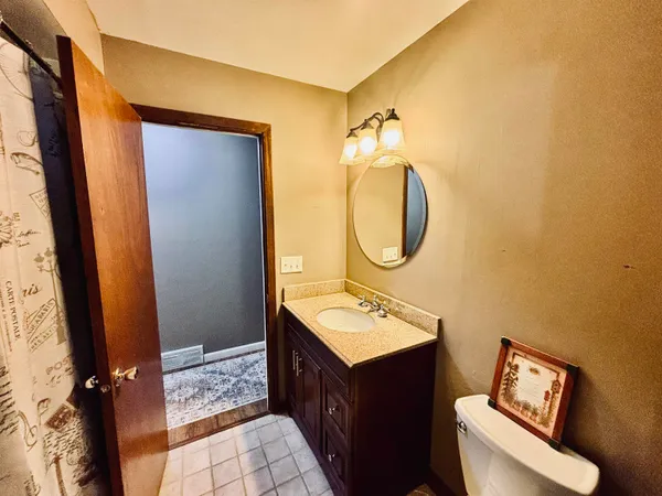 a bathroom with a sink mirror vanity and toilet