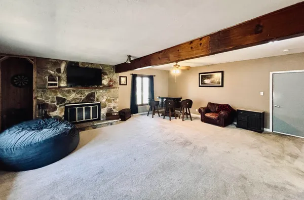 a living room with furniture kitchen and a flat screen tv