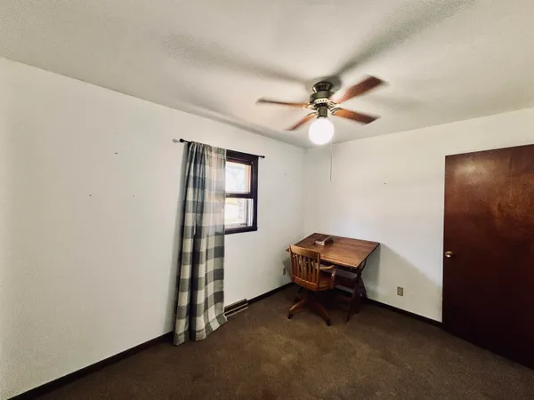 a living room with furniture and a air conditioner vent
