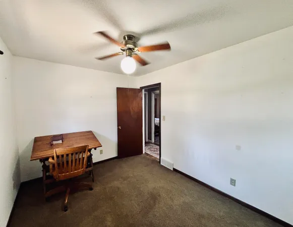 a view of a room with wooden floor and ceiling fan