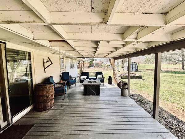 a view of a patio with couches plants and wooden floor