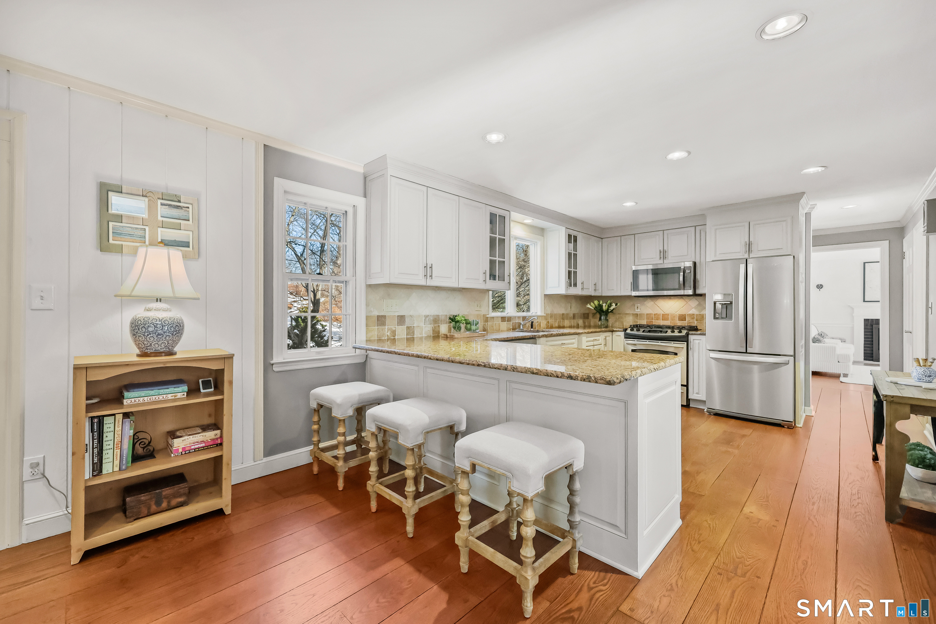 610 Unquowa Road Fairfield, CT 06824 - Photo 19 of 43 a kitchen with stainless steel appliances granite countertop a refrigerator a stove top oven and a dishwasher with wooden floor