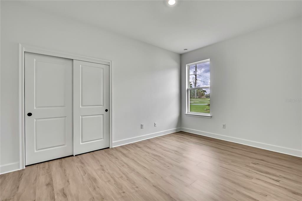 6589 Freeport Drive Spring Hill, FL 34608 - Photo 38 of 63 a view of an empty room with wooden floor and a window