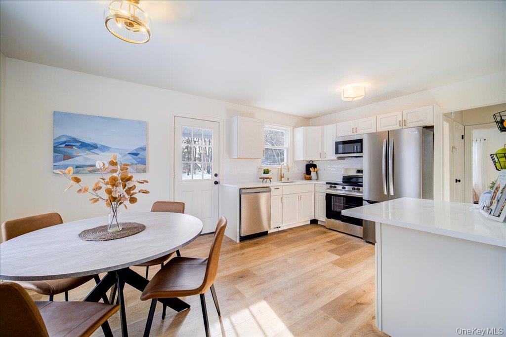 392 Titusville Road Poughkeepsie, NY 12603 - Photo 13 of 43 a kitchen with stainless steel appliances kitchen island granite countertop a dining table chairs and a refrigerator