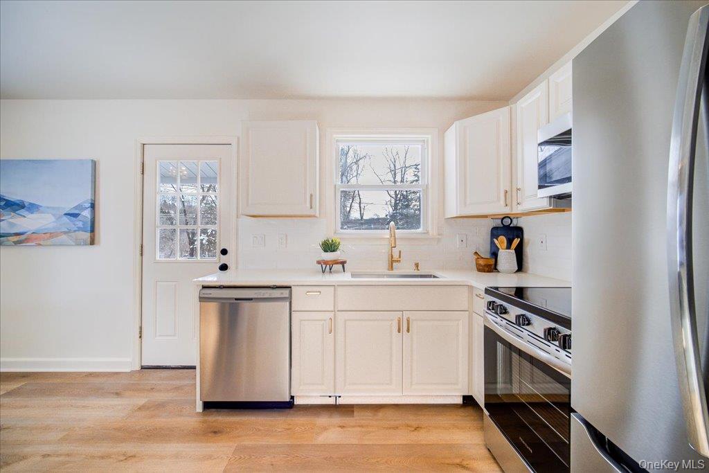 392 Titusville Road Poughkeepsie, NY 12603 - Photo 17 of 43 a kitchen with stainless steel appliances a sink cabinets and a window