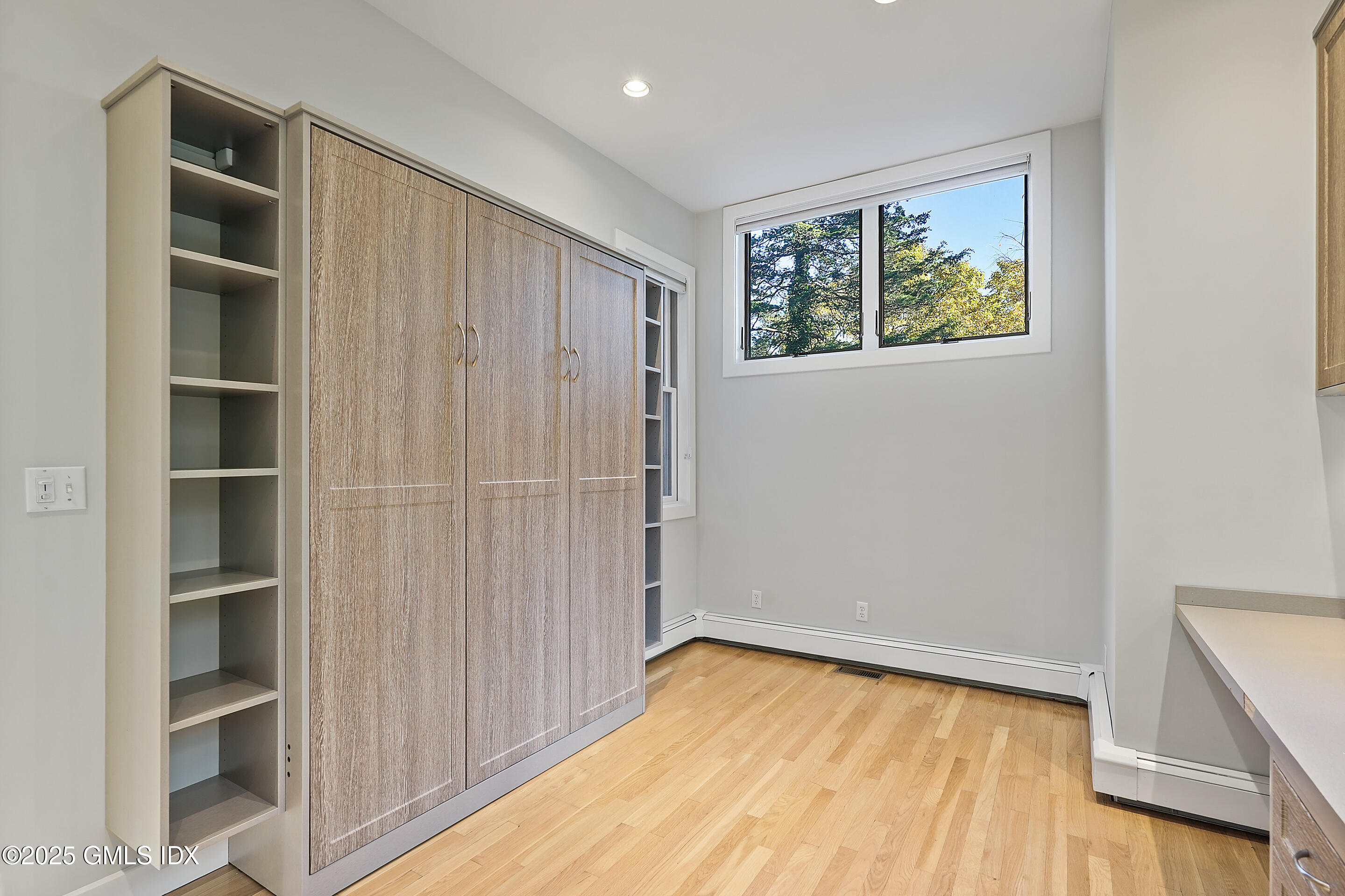 249 Shore Road Greenwich, CT 06830 - Photo 12 of 38 a view of an empty room with a window and wooden floor