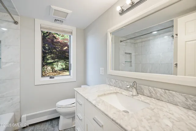 a bathroom with a granite countertop sink toilet and shower