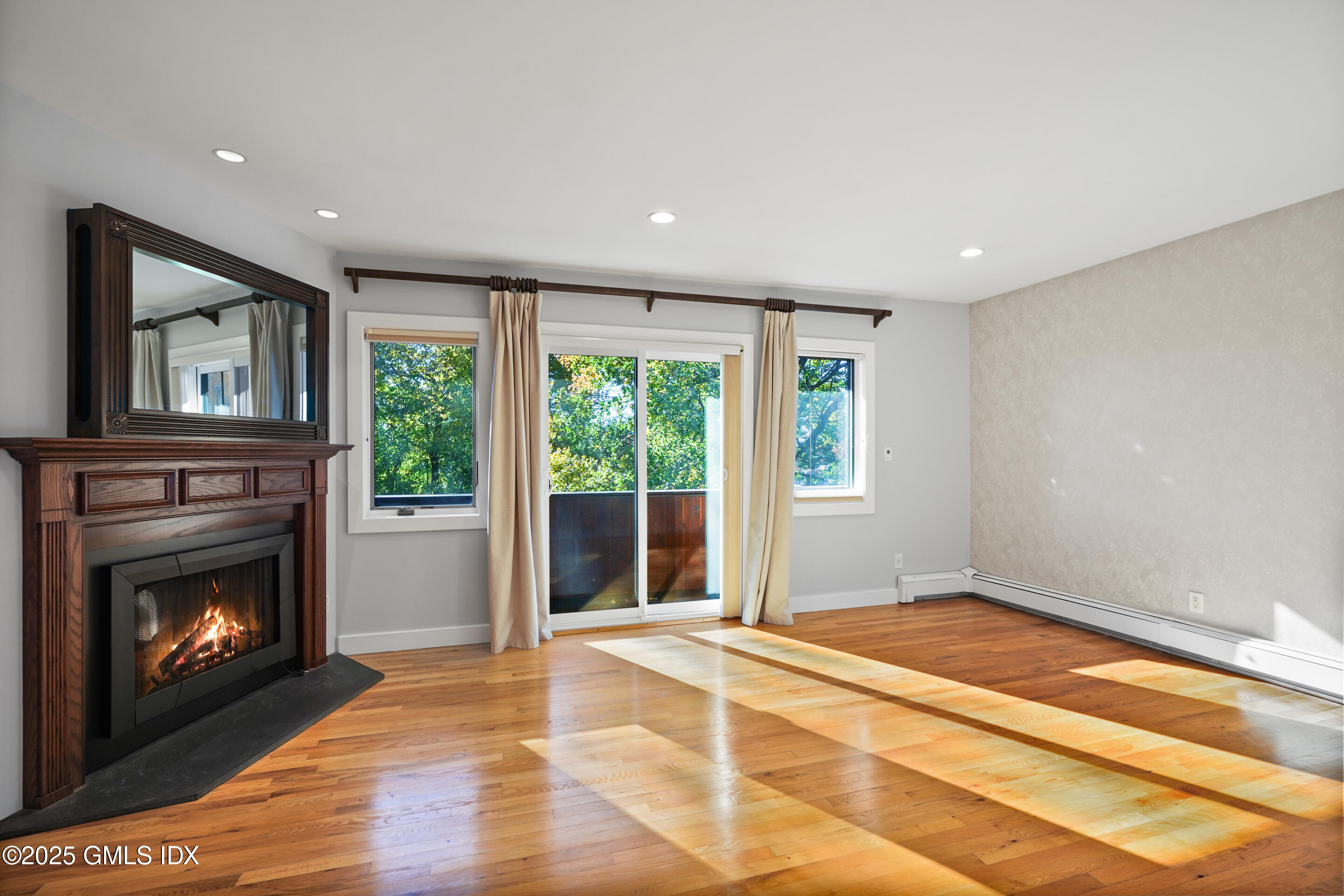 249 Shore Road Greenwich, CT 06830 - Photo 17 of 38 a living room with a fireplace and a floor to ceiling window