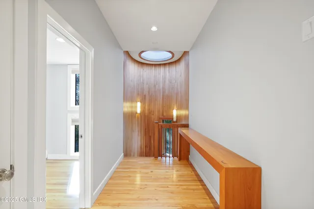 a view of a hallway with entryway and wooden floor