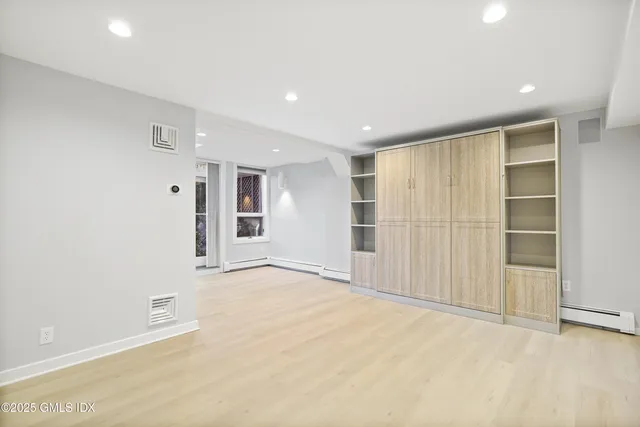 an empty room with cabinet and mirrors