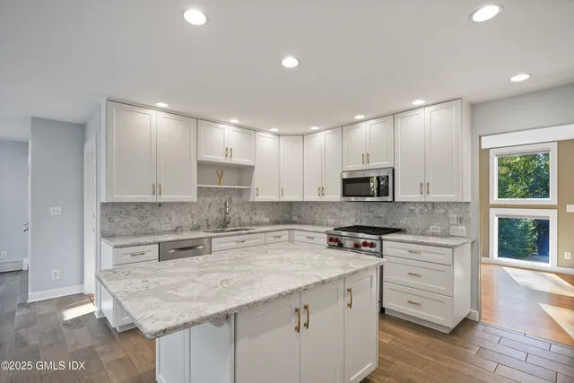 a kitchen with a stove a sink a microwave a counter and cabinets