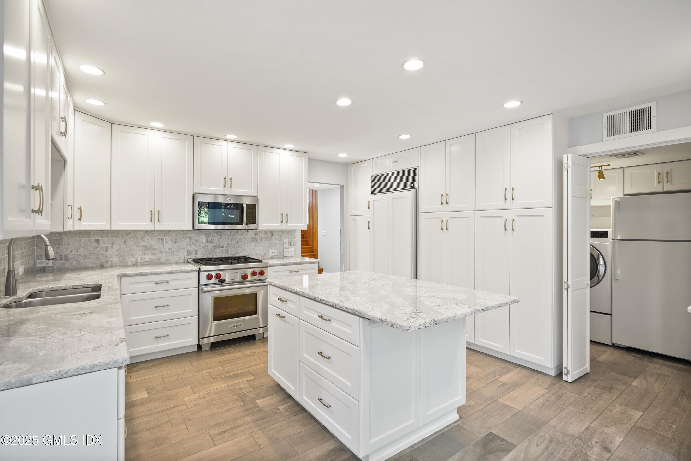 249 Shore Road Greenwich, CT 06830 - Photo 4 of 38 a kitchen with white cabinets and stainless steel appliances