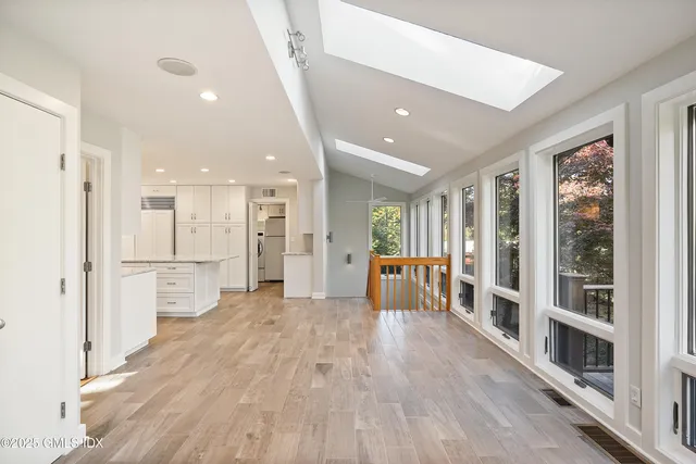a view of a kitchen with refrigerator and wooden floor