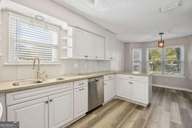 a kitchen with white cabinets and refrigerator